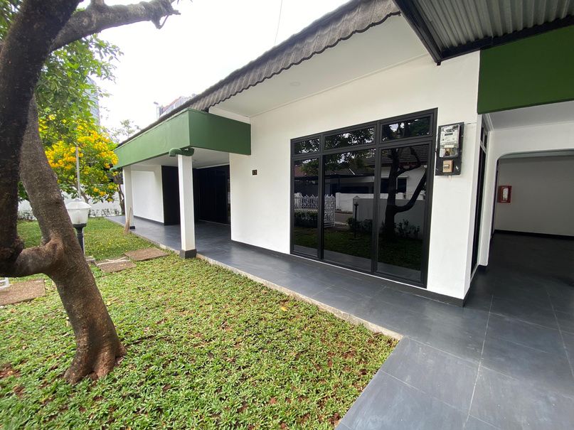 Tampak luar Rumah Dinas Jabatan E5 setelah rehabilitasi, dengan dinding putih dan taman rumput