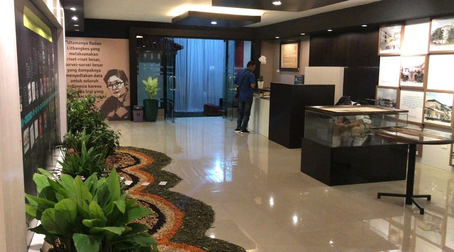 Area pamer galeri Badan Litbang Kesehatan dengan lantai granit dan tanaman hias